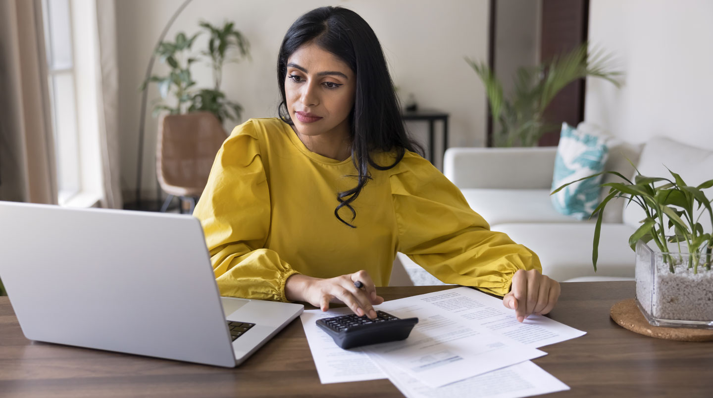 Mains d'un épargnant consultant son relevé de contrat d'assurance vie avec calculette pour vérifier l'ancienneté de 8 ans